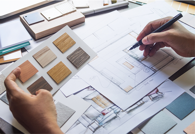 mani che disegnano un progetto di arredo